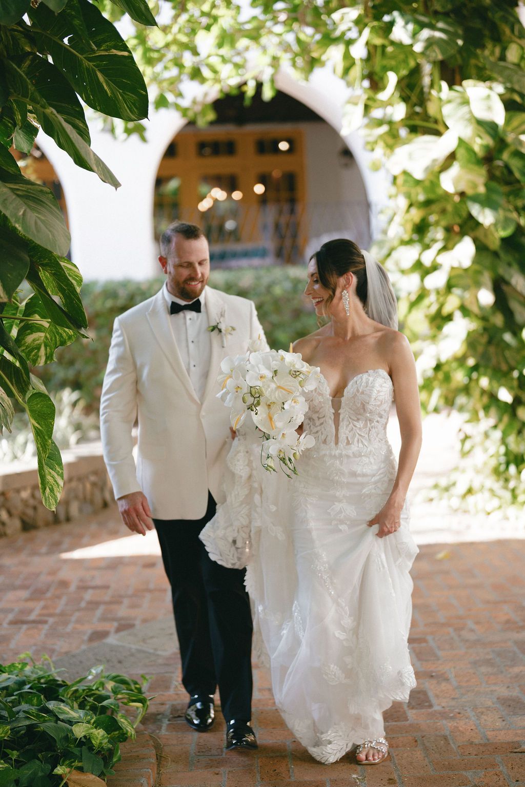 Newlyweds walking together through tropical surroundings during their Costa Rica wedding.