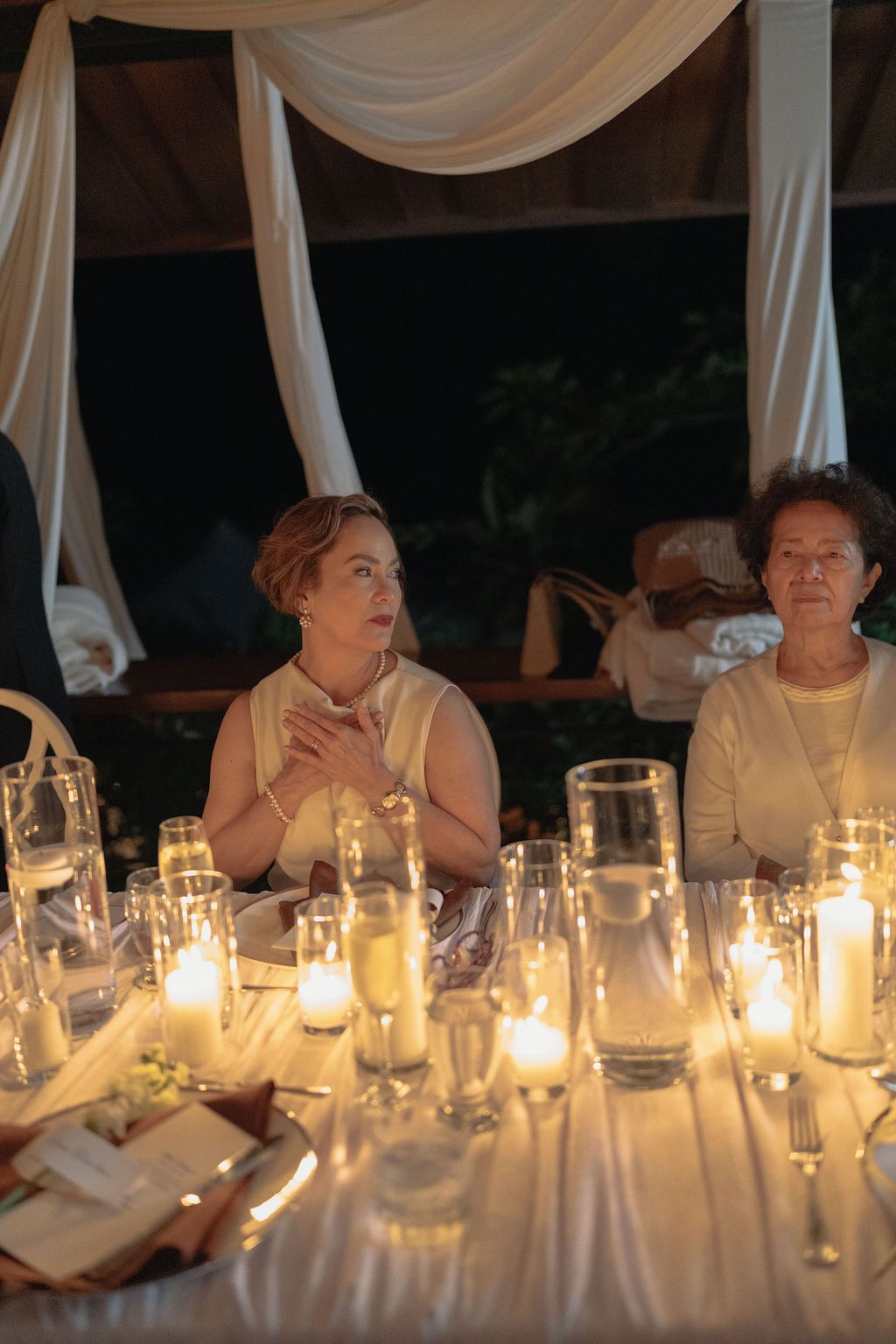 Wedding guest surrounded by glowing candles during an intimate dinner in Monteverde