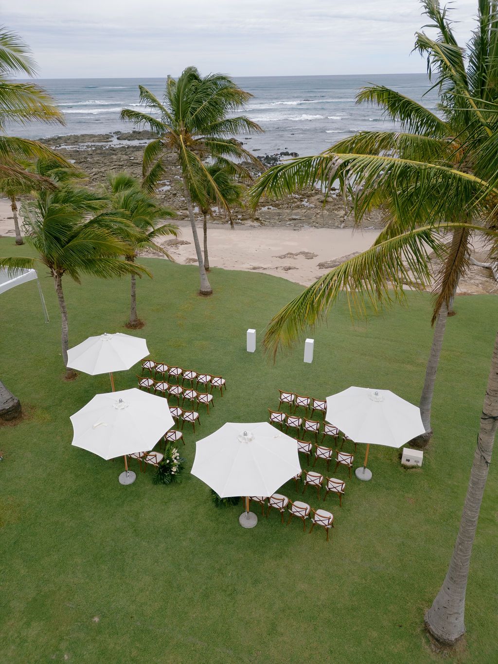 Elevated view of the oceanfront ceremony lawn and palm trees at Las Palapas, Hacienda Pinilla.