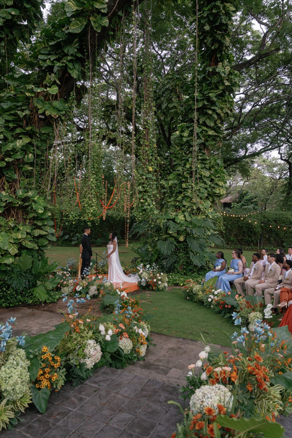 Outdoor garden wedding ceremony surrounded by tropical greenery at El Mangroove