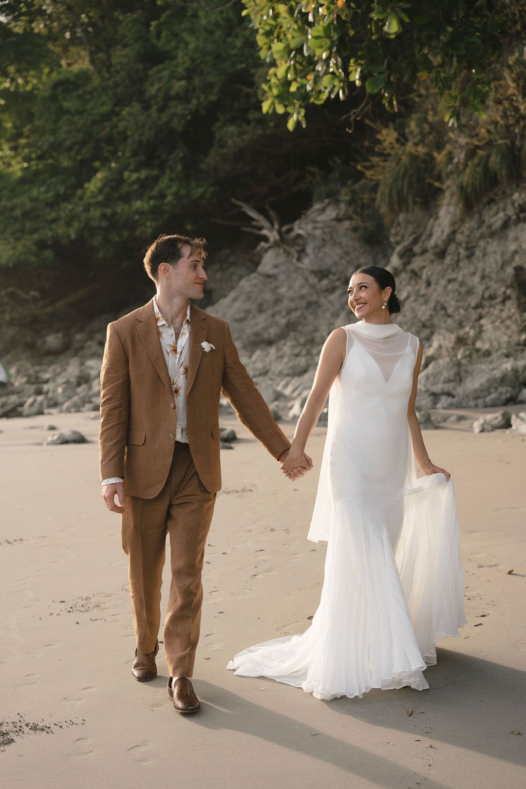 Natural portrait of the newlyweds walking together on the beach in Manuel Antonio.