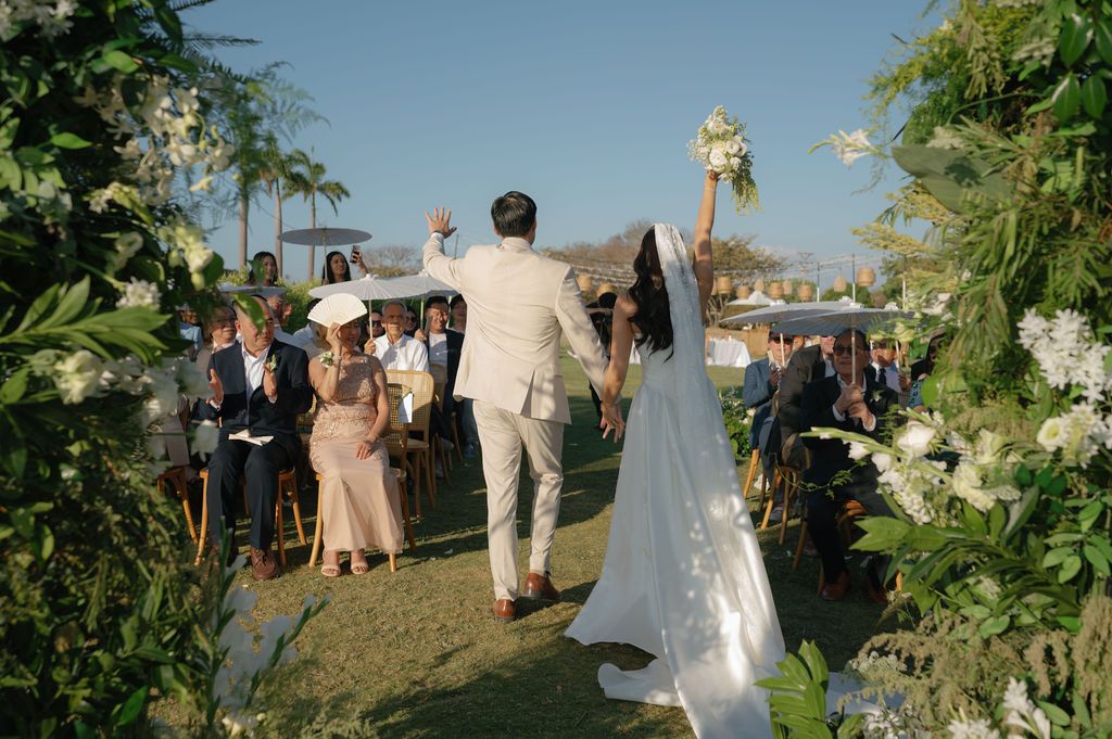 Newlyweds celebrating as they walk back down the aisle after their outdoor wedding ceremony in Costa Rica.