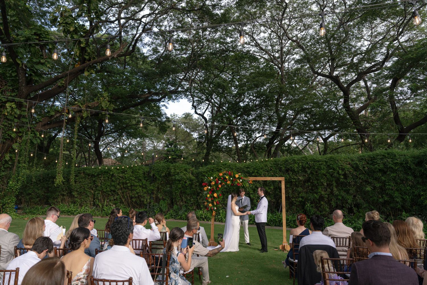 Couple holding hands during their intimate garden wedding ceremony