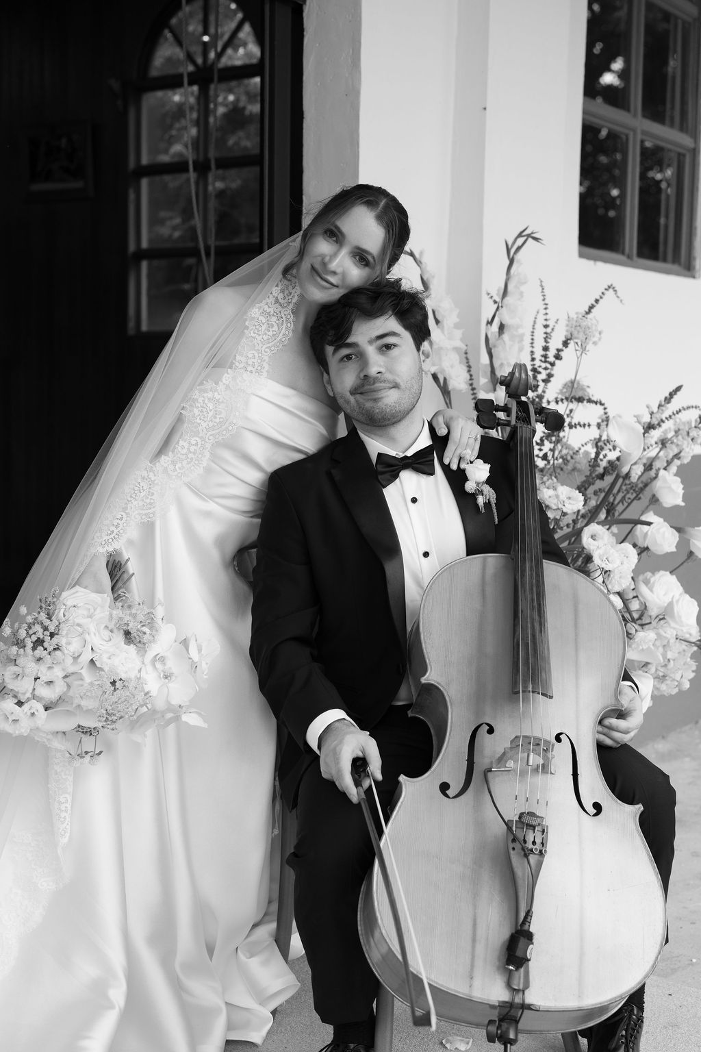 Black and white portrait of newlyweds beside the cellist after their wedding ceremony