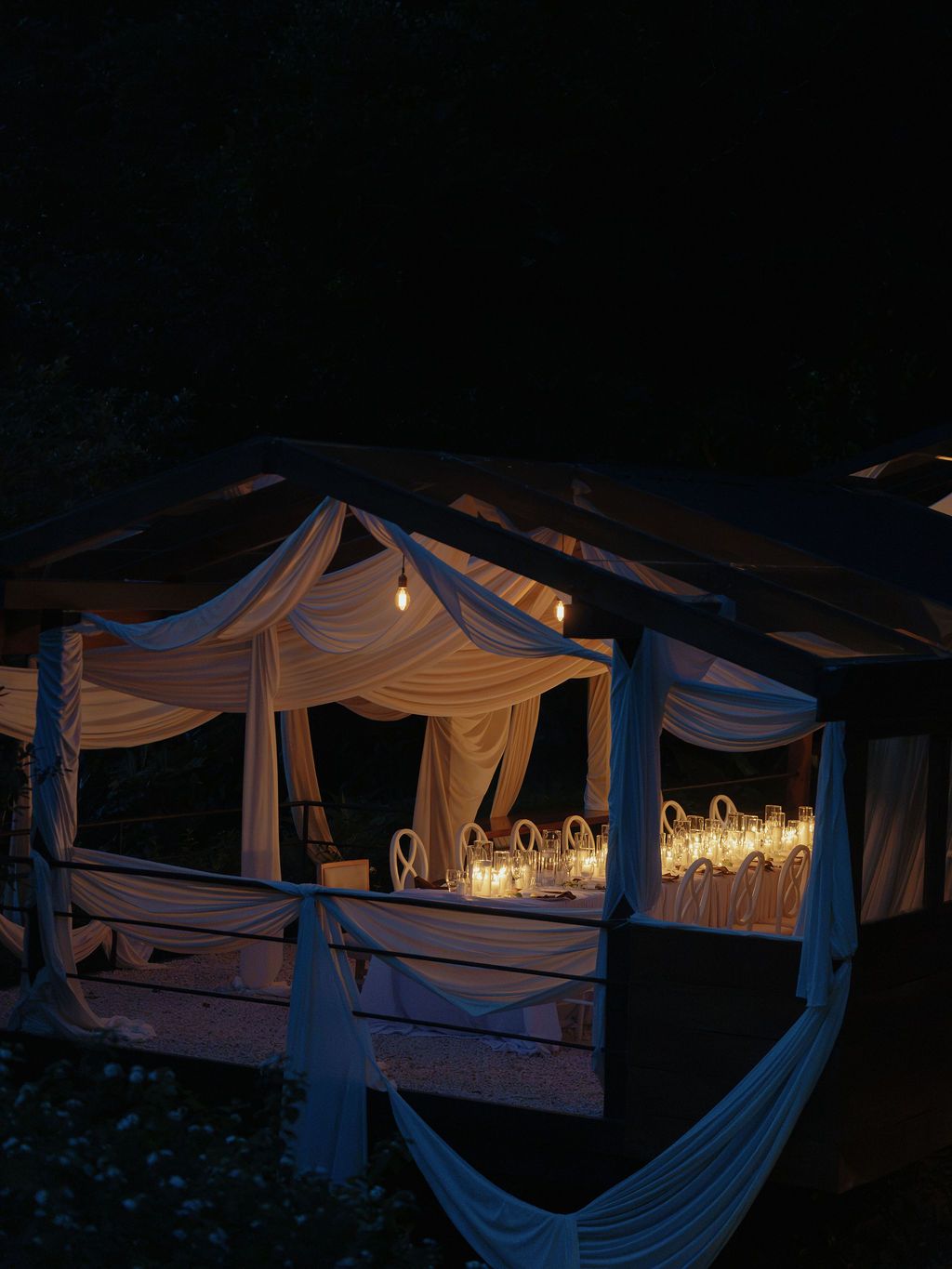 Intimate wedding reception pavilion glowing with candlelight at night in Monteverde