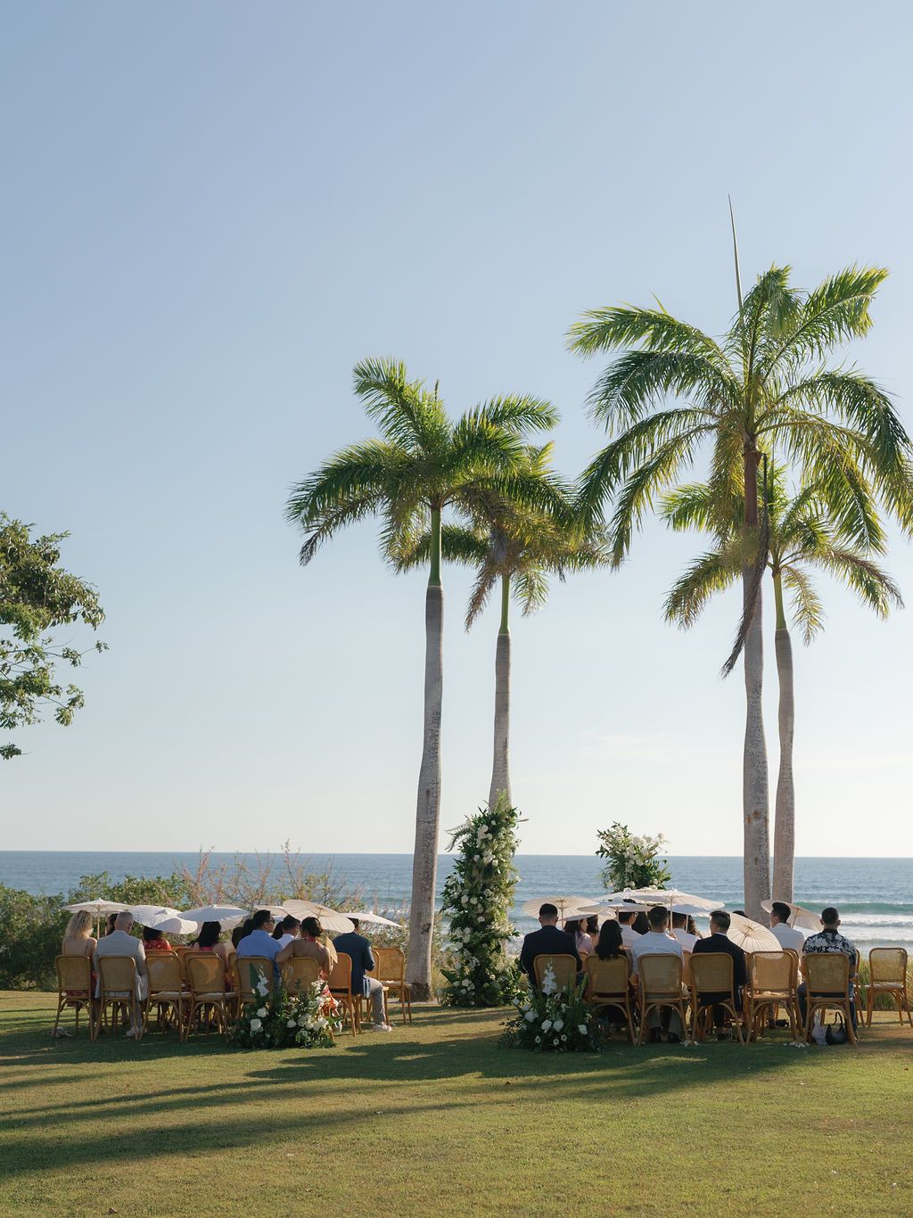 Outdoor wedding ceremony surrounded by palm trees at Hacienda Pinilla in Costa Rica.