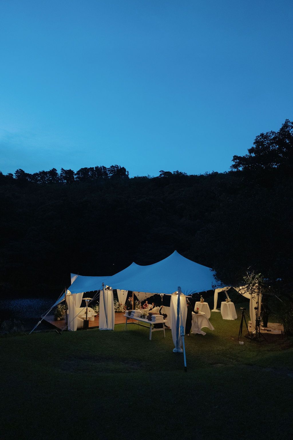 Outdoor wedding tent glowing at blue hour in the forests of Monteverde