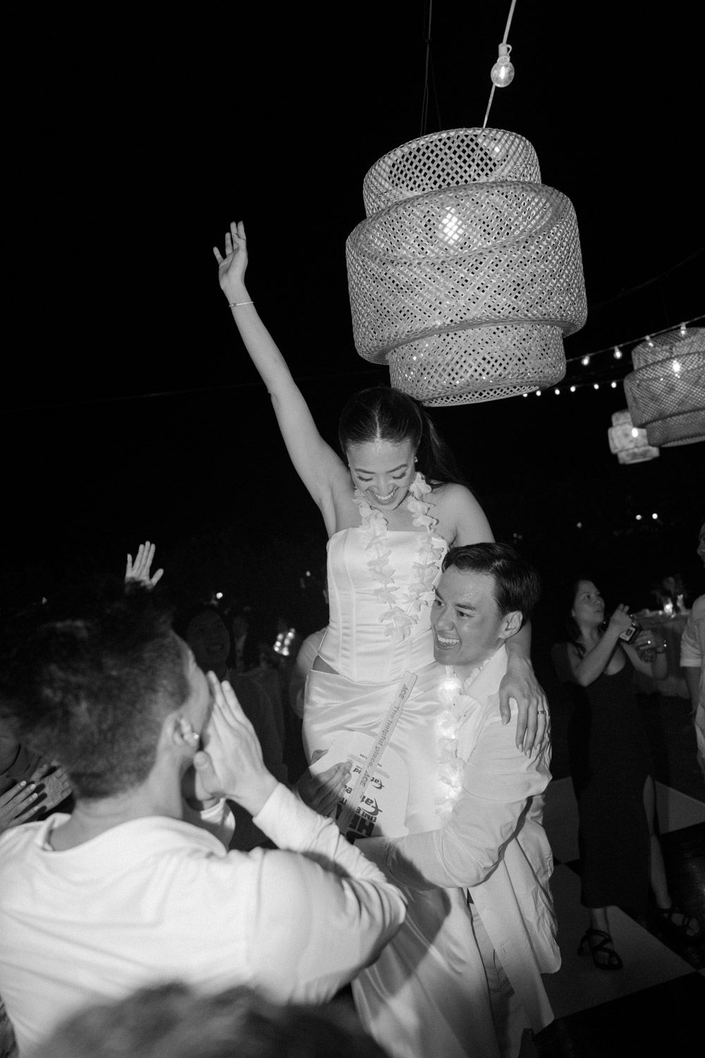 Black-and-white photo of Ashley lifted above the dance floor during her wedding celebration in Costa Rica.
