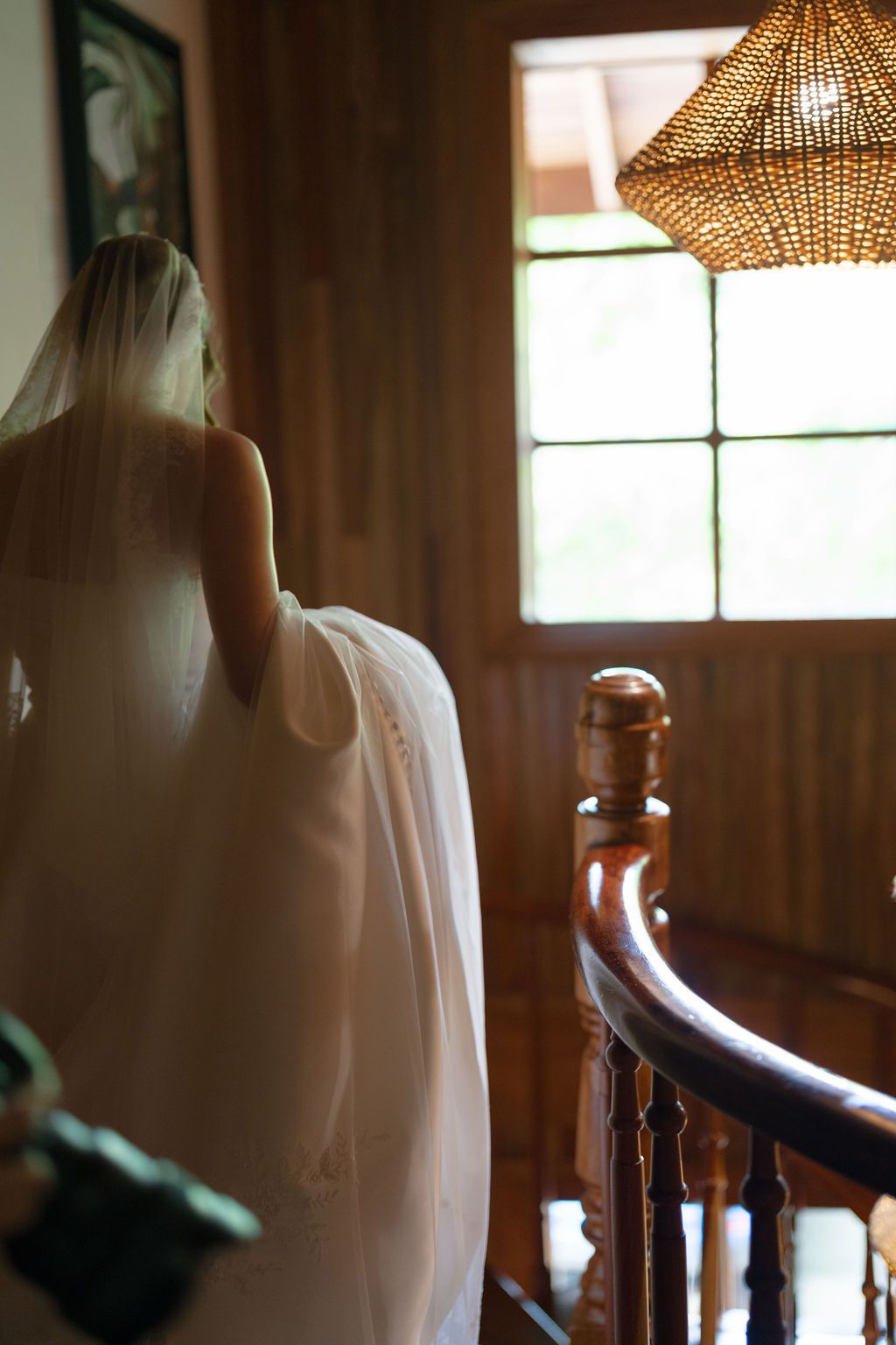 Bride carrying her wedding dress while walking through a wooden house in Monteverde