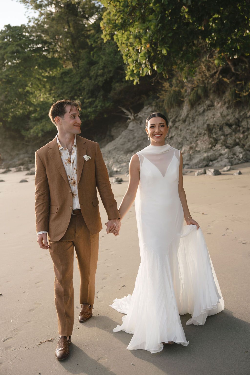 Couple walking along the beach during their intimate wedding in Manuel Antonio, Costa Rica.