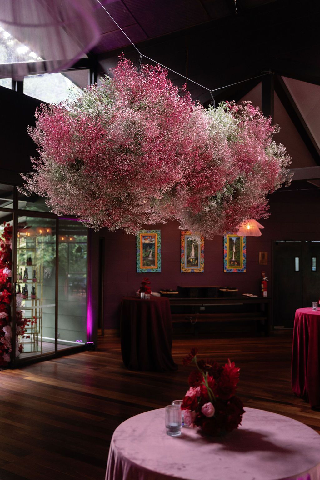 Pink and white floral installation hanging above a wedding welcome party in Costa Rica