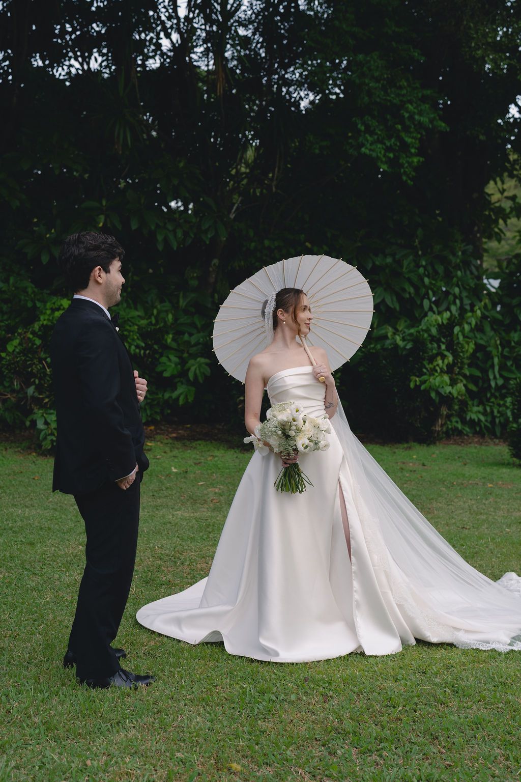 Bride and groom portrait with a white parasol surrounded by lush Monteverde greenery