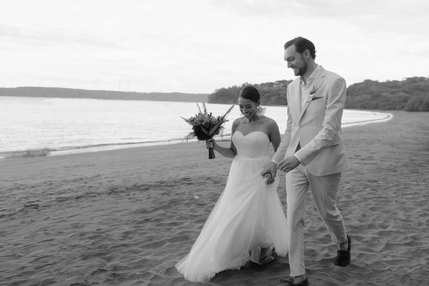 Bride and groom walking together along the beach after their wedding ceremony in Costa Rica.