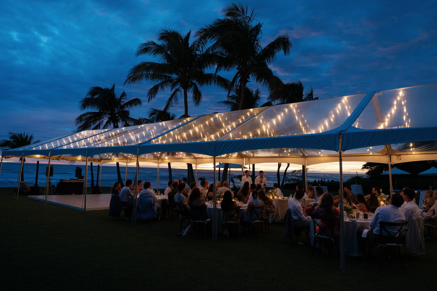 Destination wedding reception under a clear tent overlooking the ocean in Costa Rica.