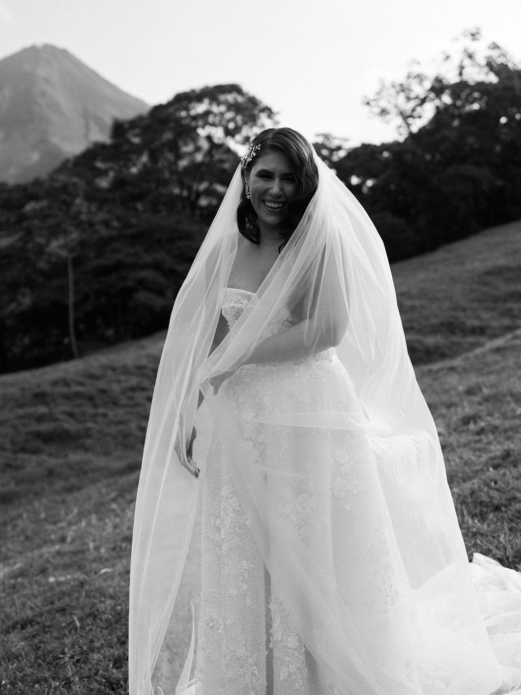 Smiling bride wrapped in her veil during her Arenal elopement