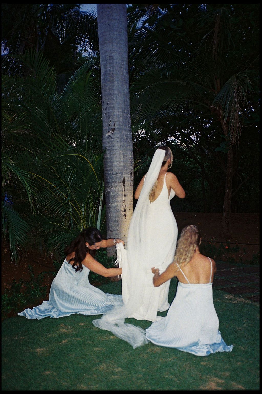 Bridesmaids adjusting the bride’s dress in a candid film photograph at Hacienda Pinilla