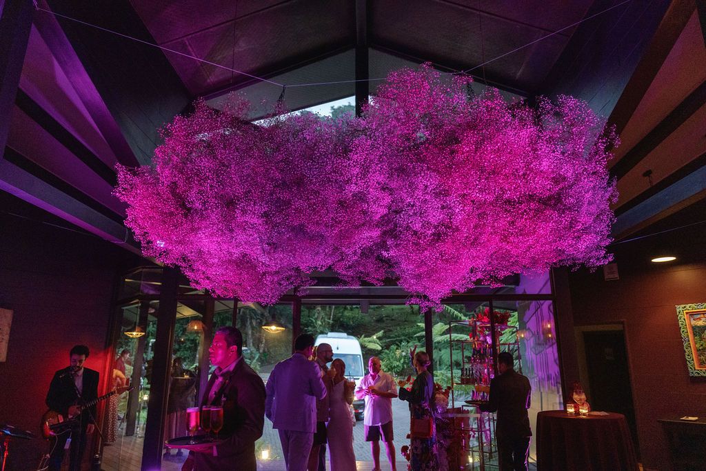 Large pink floral installation above the welcome party space for a Costa Rica destination wedding