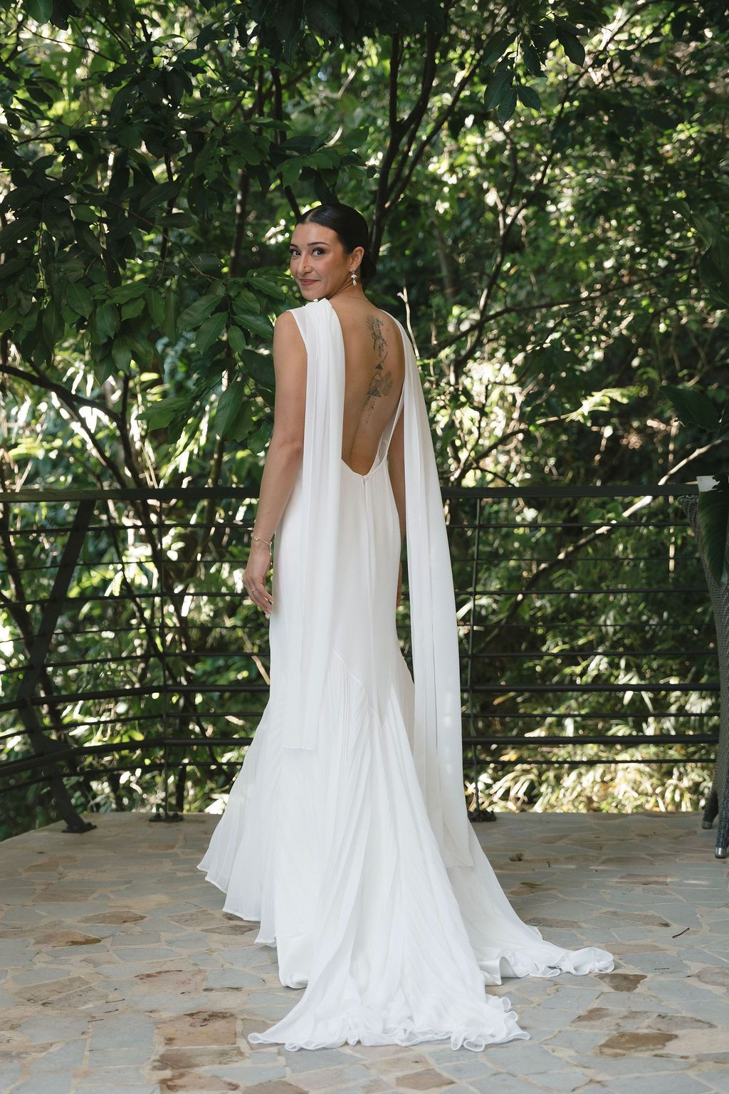 Bride showing the open back of her wedding dress against the Manuel Antonio rainforest.