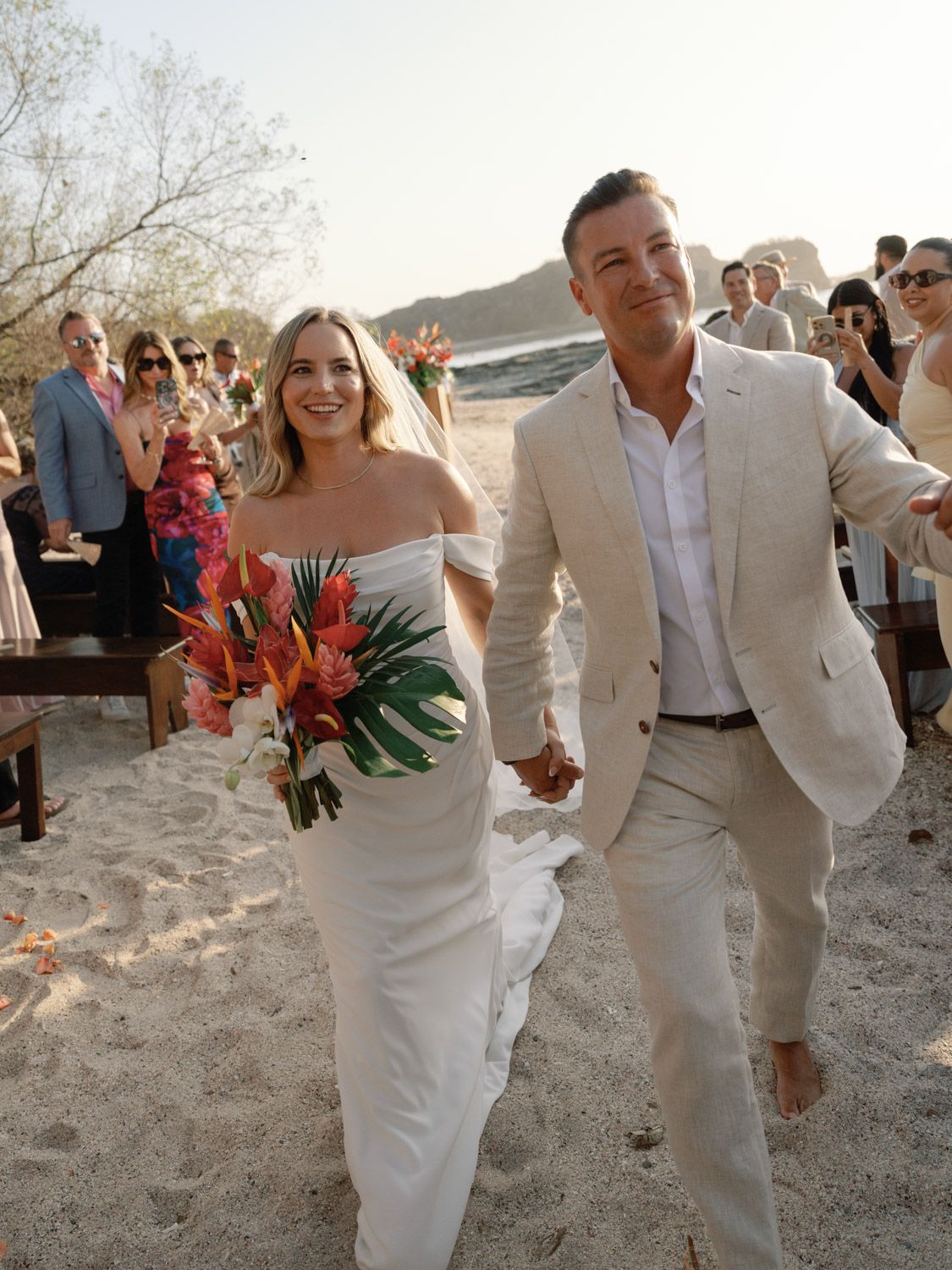 Karlee and Ryan walking past their guests after their beach wedding ceremony in Nosara, Costa Rica.