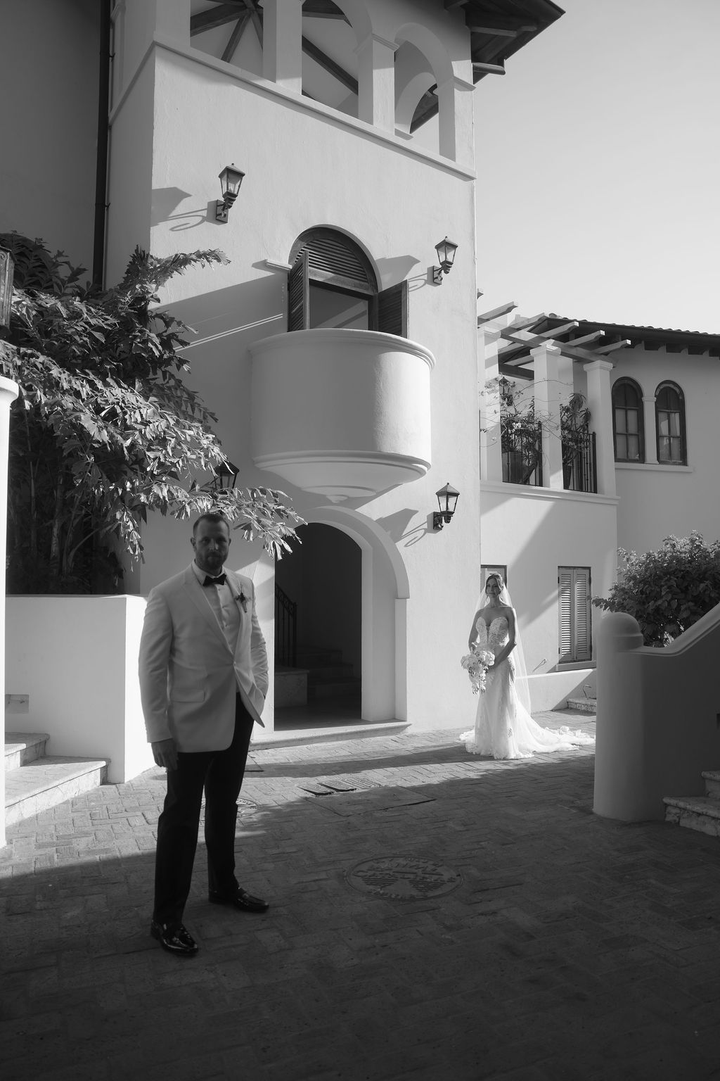 Black and white editorial portrait of a bride and groom surrounded by tropical architecture in Costa Rica.