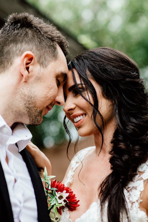 A romantic moment between newlyweds with red flower boutonniere, bridal portraits after their wedding in Phoenix Arizona
