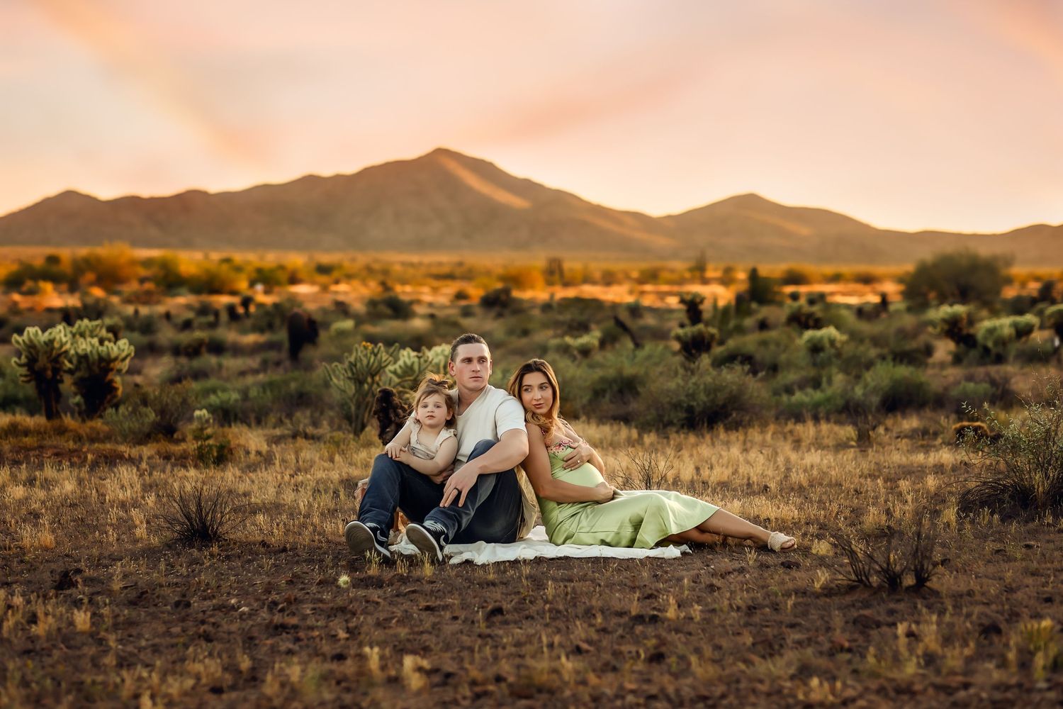 A gathering in the desert at sunset with mountains in the background.