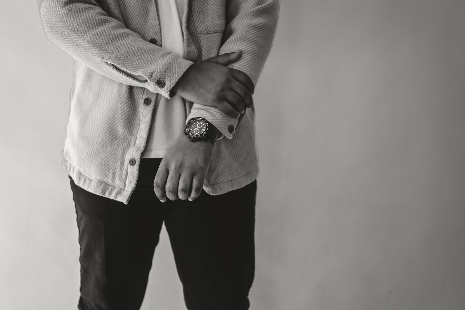 Close-up of person in light jacket checking time on wristwatch.