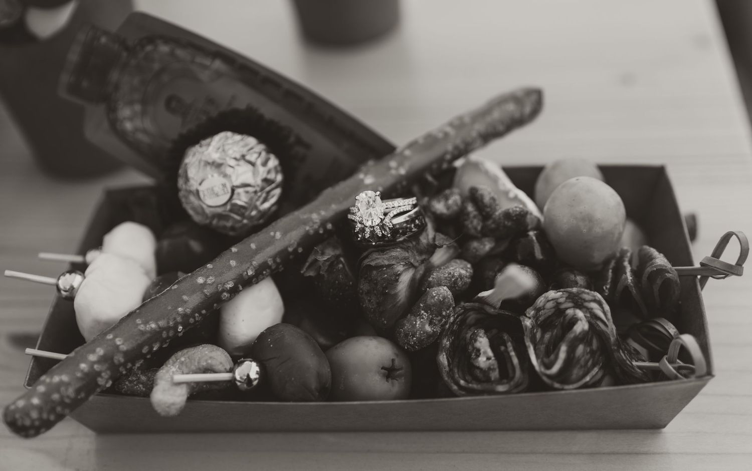 Black and white still life photograph of natural objects and trinkets arranged in a vintage wooden box.