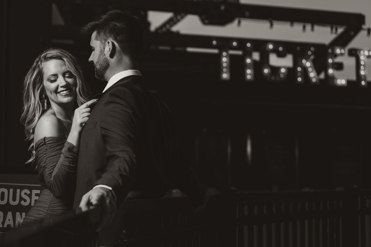 A black and white intimate moment captured between a couple dancing in a dimly lit venue.