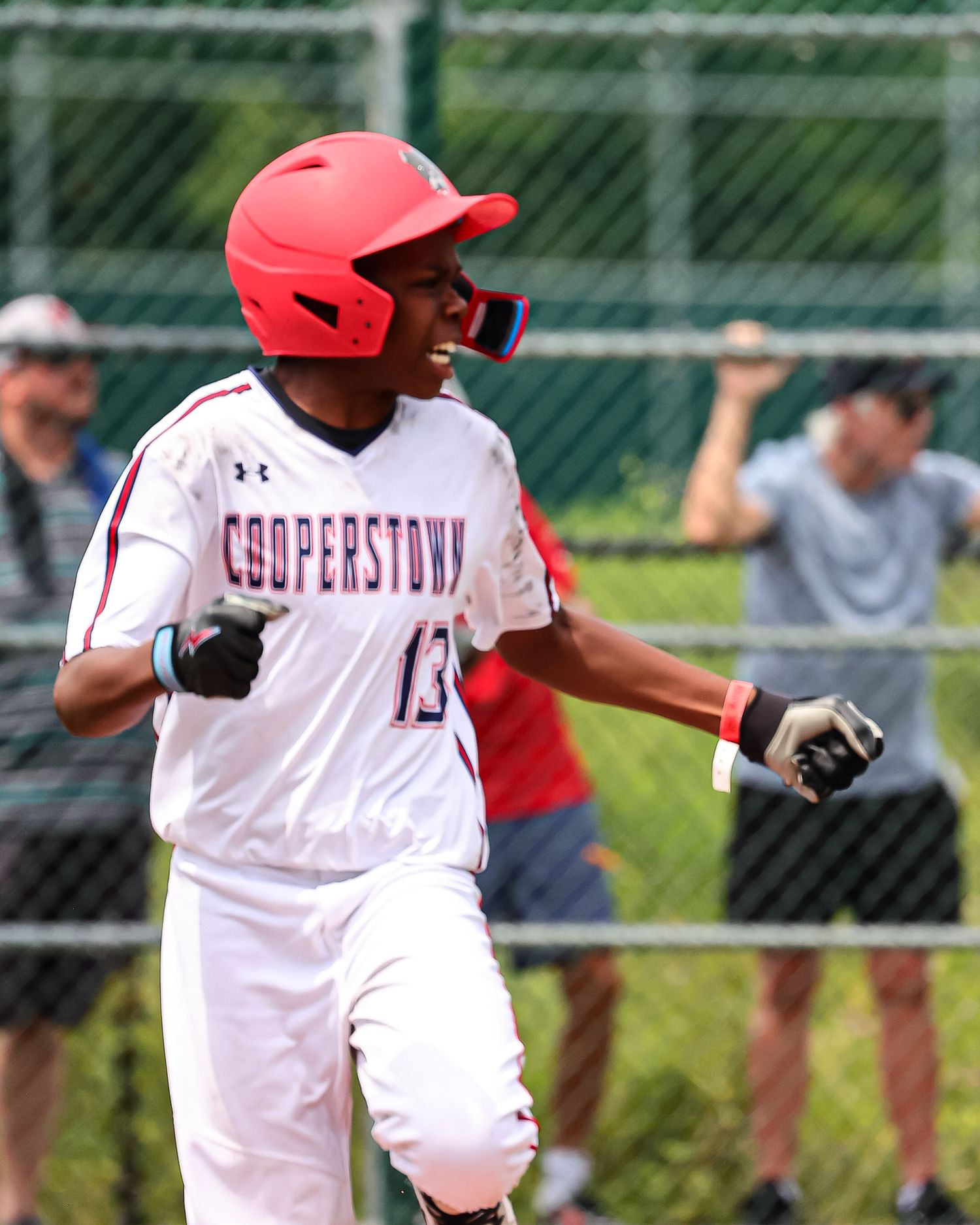 A baseball player in a white uniform with red accents takes a batting stance at home plate during a game.
