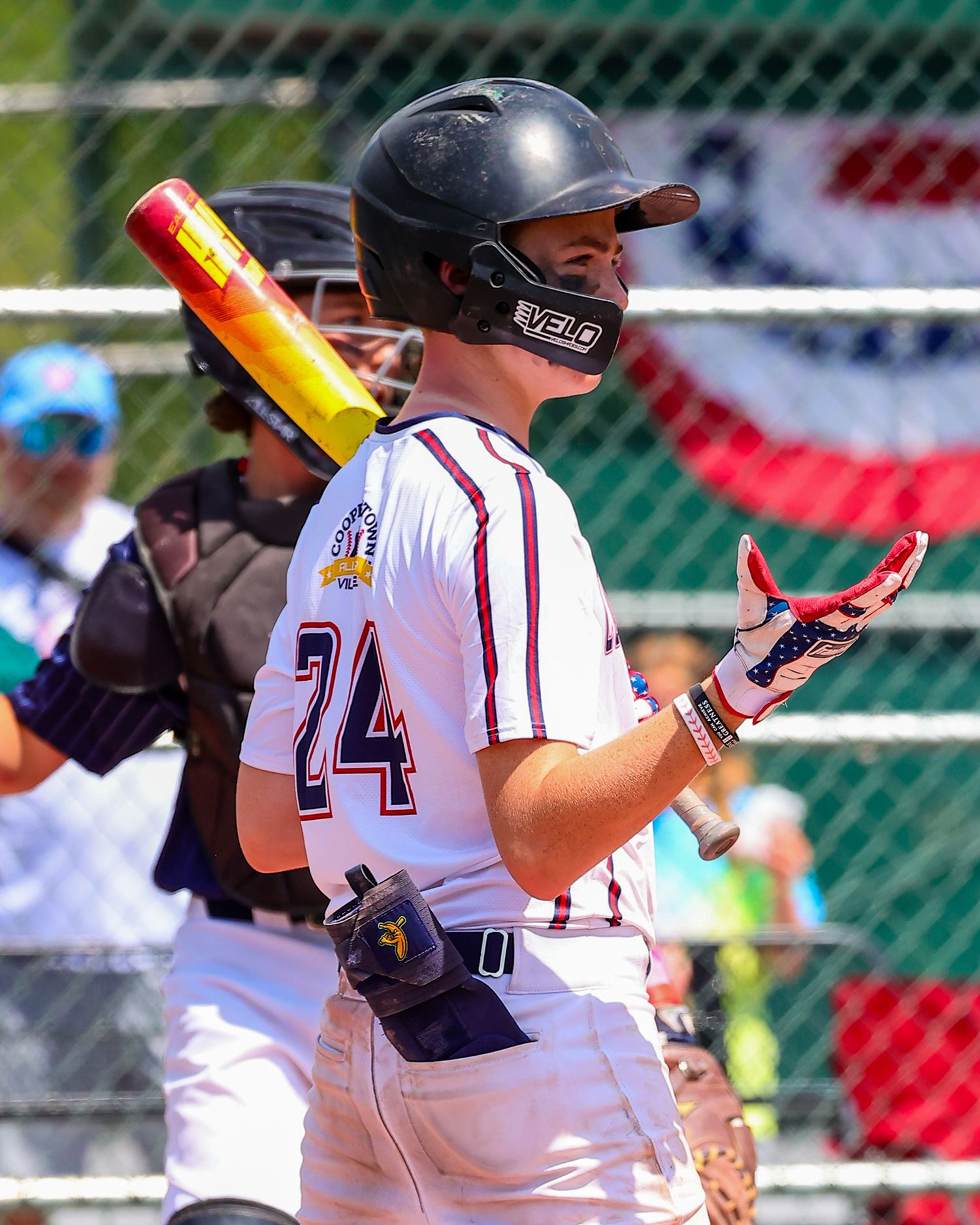 Baseball players in white uniforms with maroon accents line up in batting stances during a game.