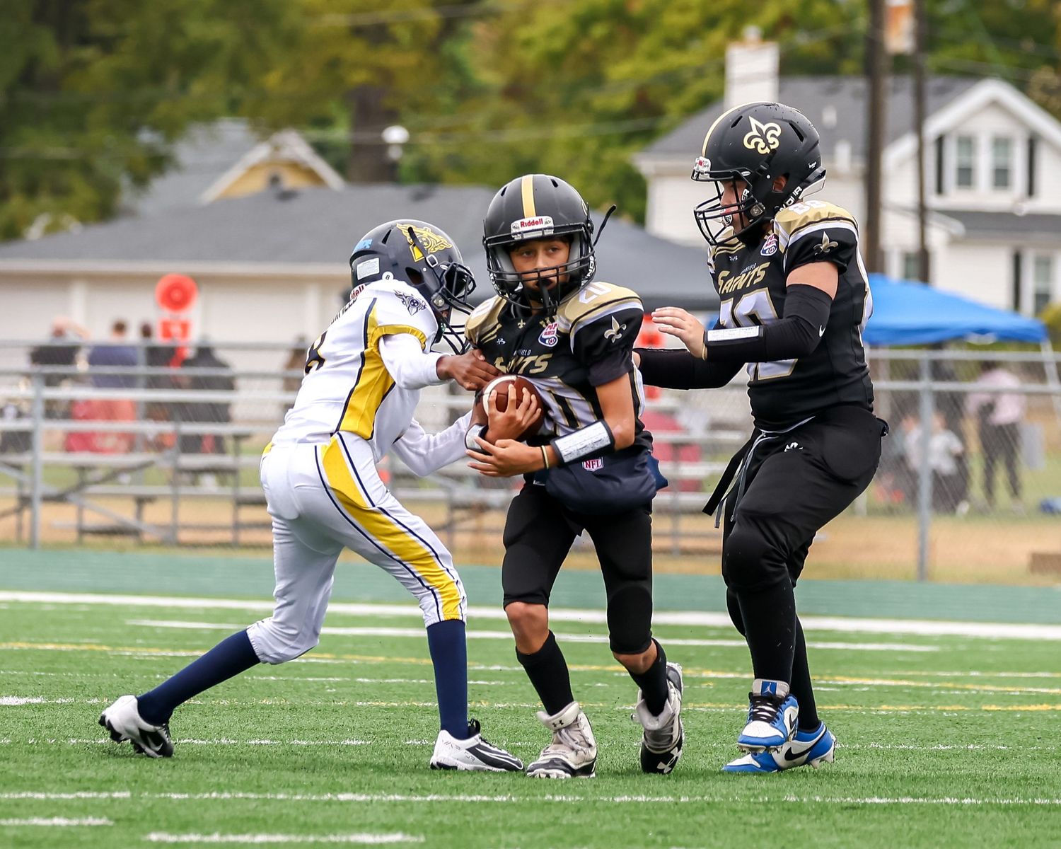 Football players from opposing teams compete for the ball during game action.