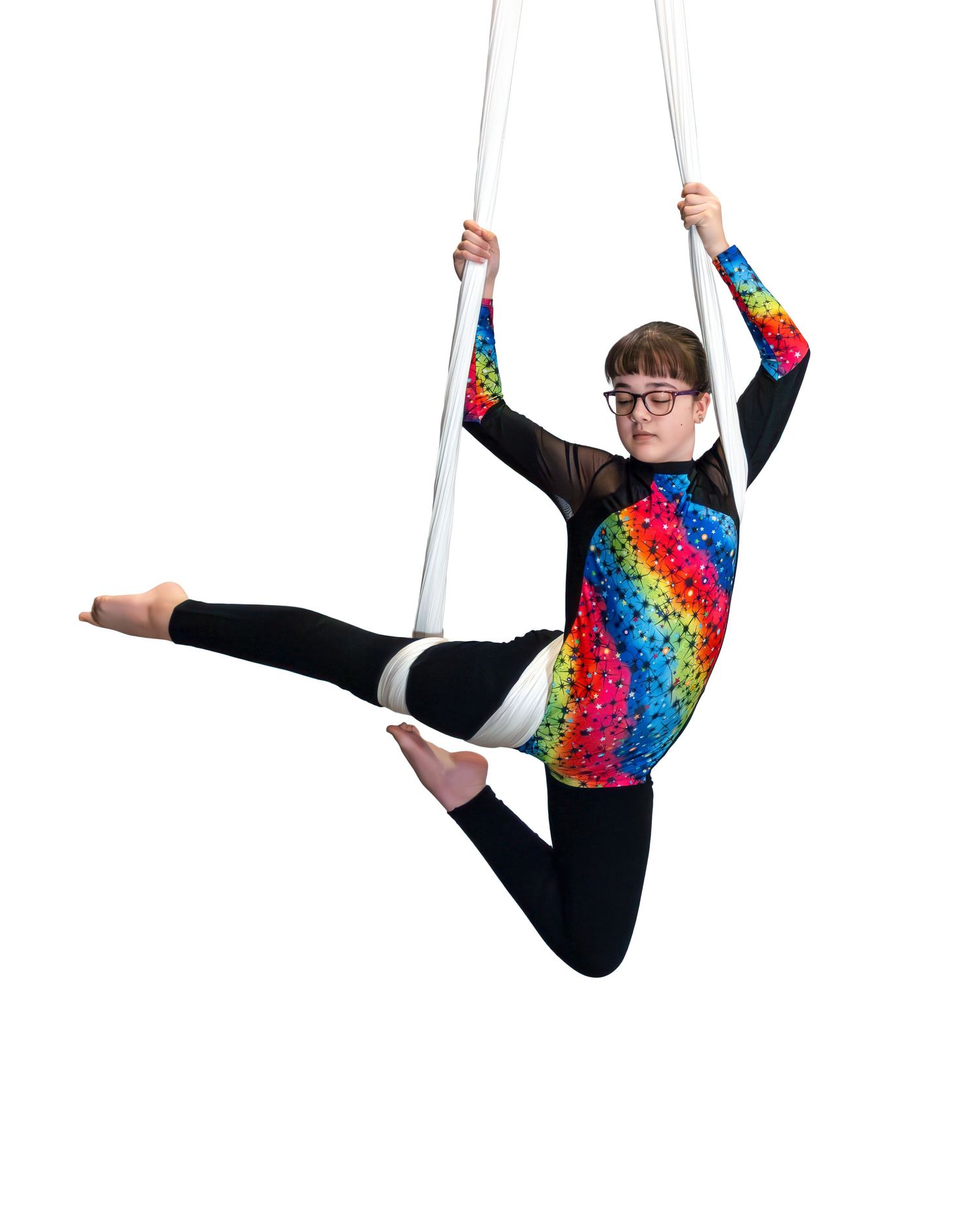 Performer in rainbow leotard executing aerial silk dance moves against white background.