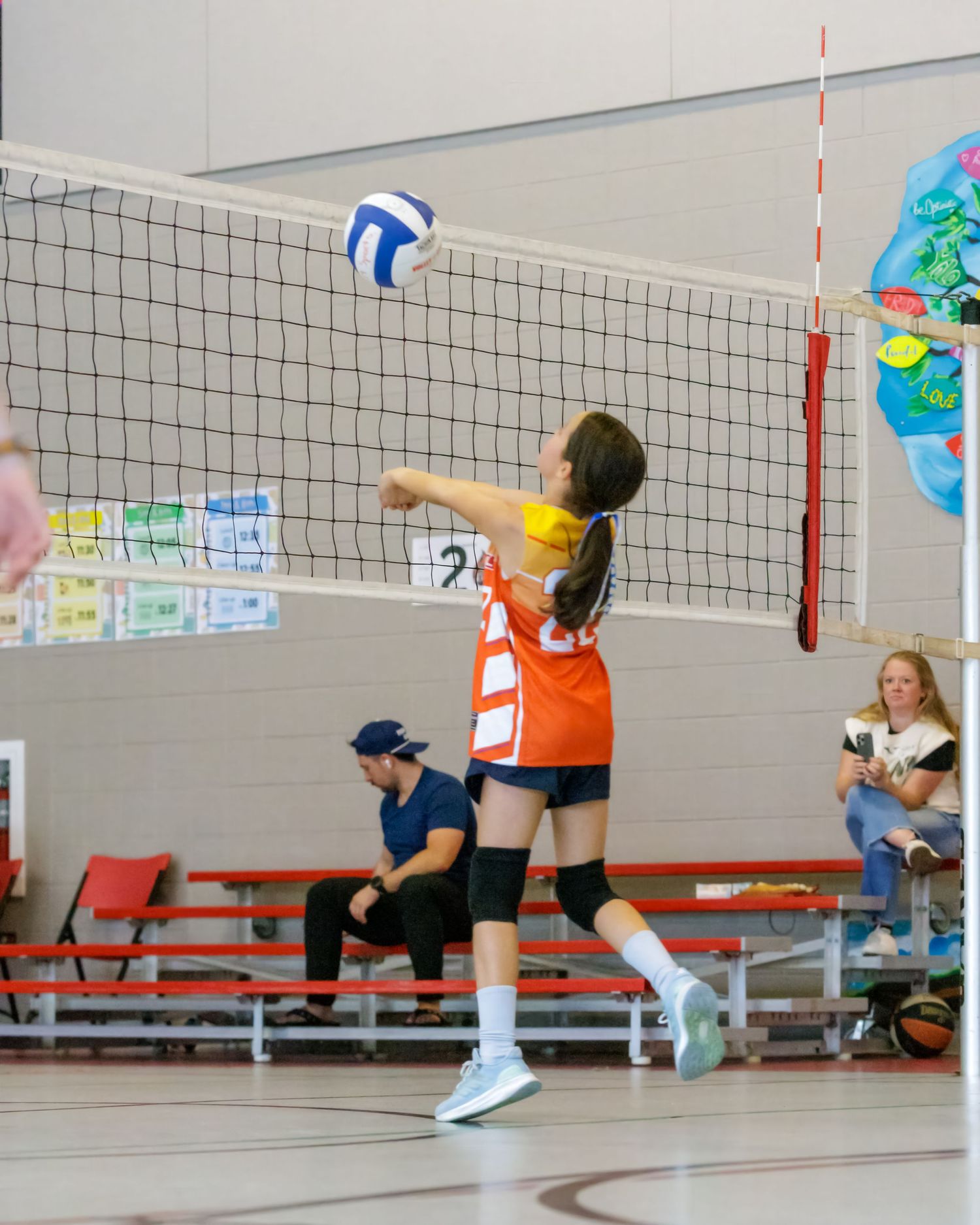 Volleyball players practice diving and defensive moves on a court with a net.