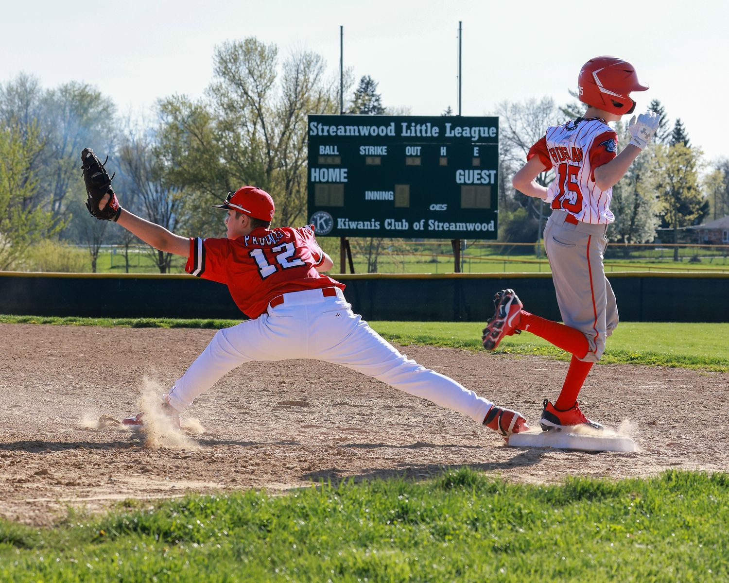 Baseball players in action at first base during competitive game.