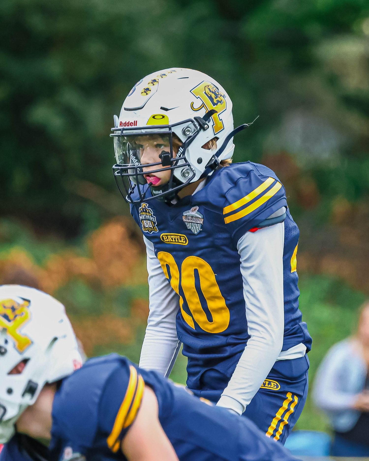 Football player in blue and white uniform number 10 standing ready on field.