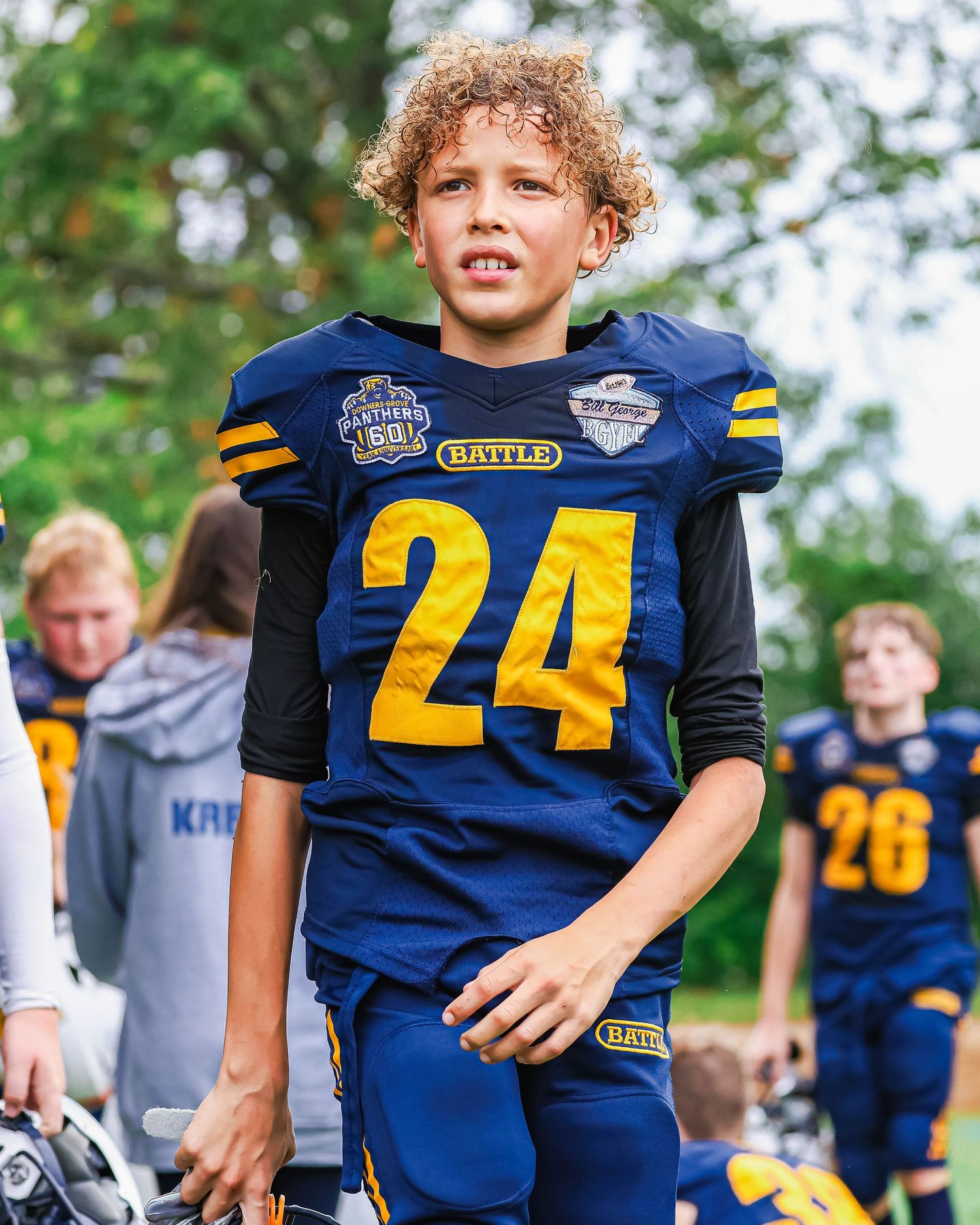 Young football player wearing navy and gold number 24 jersey during a youth football game.