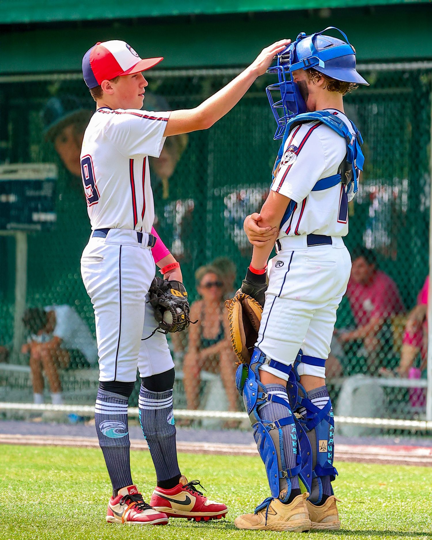 A sequence of baseball players in white and blue uniforms demonstrating proper catching stance on a grassy field.