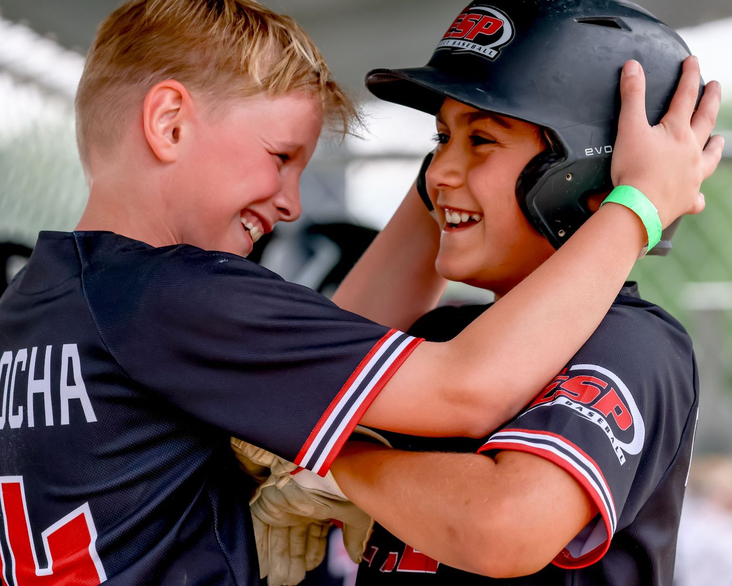 A baseball team celebrates with teammates on the field after a game or big play.