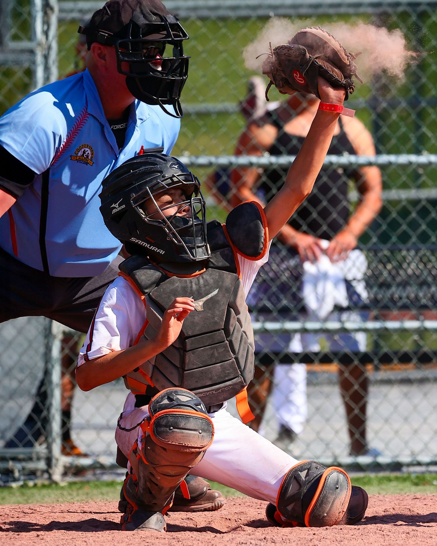 Close-up sequence of a baseball catcher's glove and protective gear behind home plate during a game.