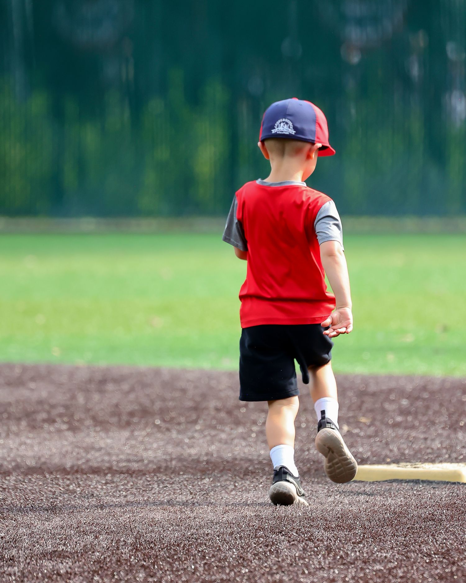 Young child running the bases at a baseball game.