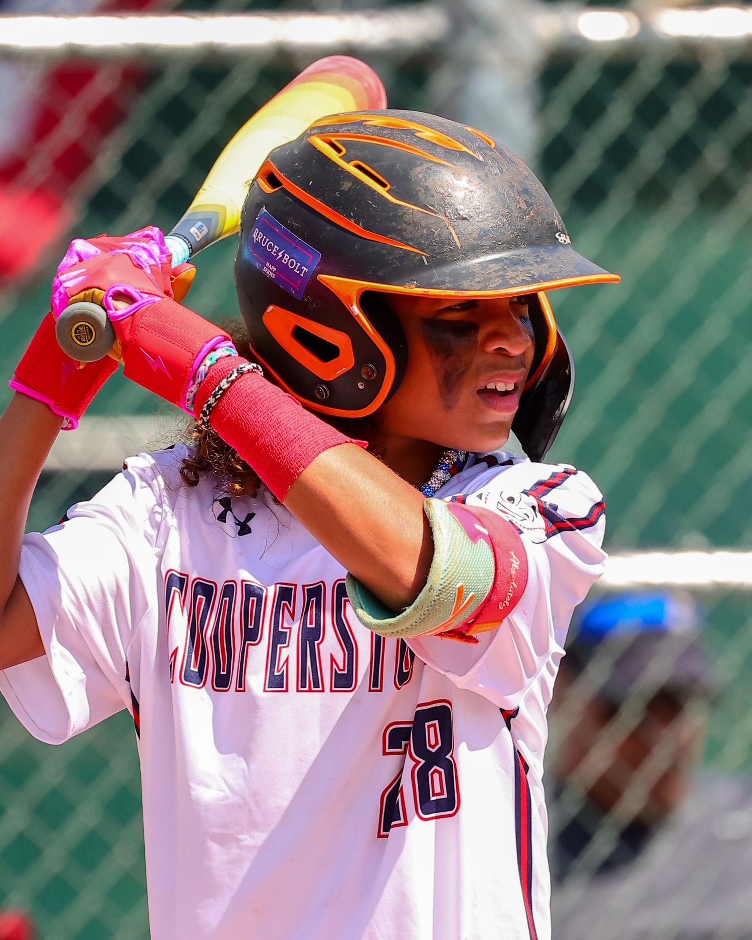 Baseball player in white uniform with number 58 takes batting stance while wearing orange and black helmet.