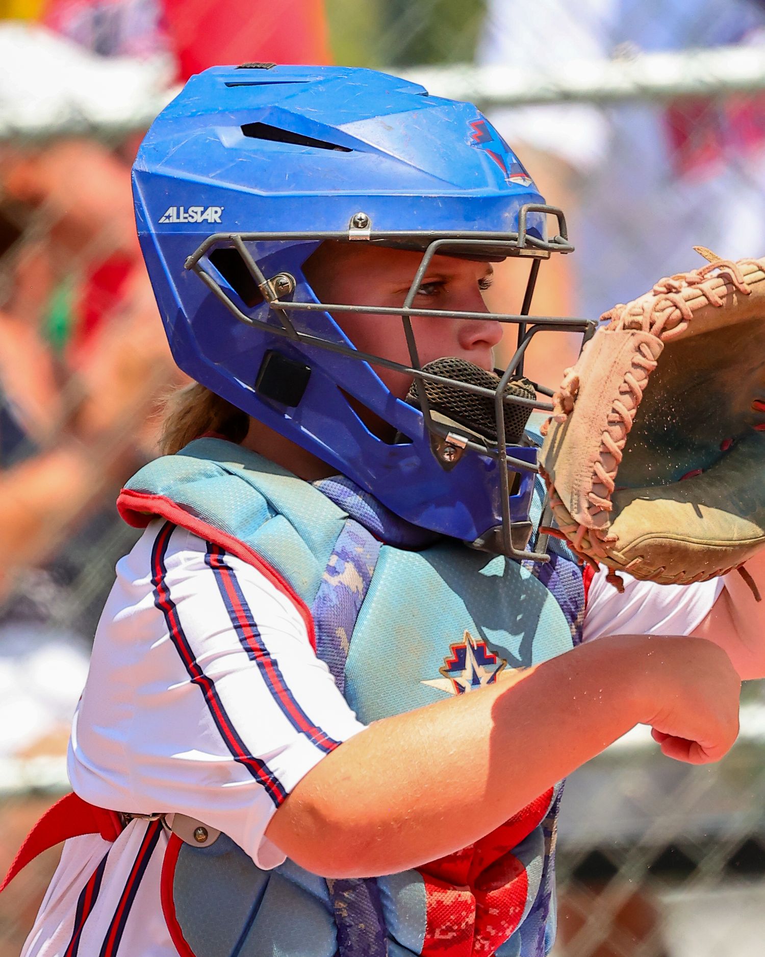 A baseball player in a blue helmet and red uniform takes a batting stance at home plate during a game.