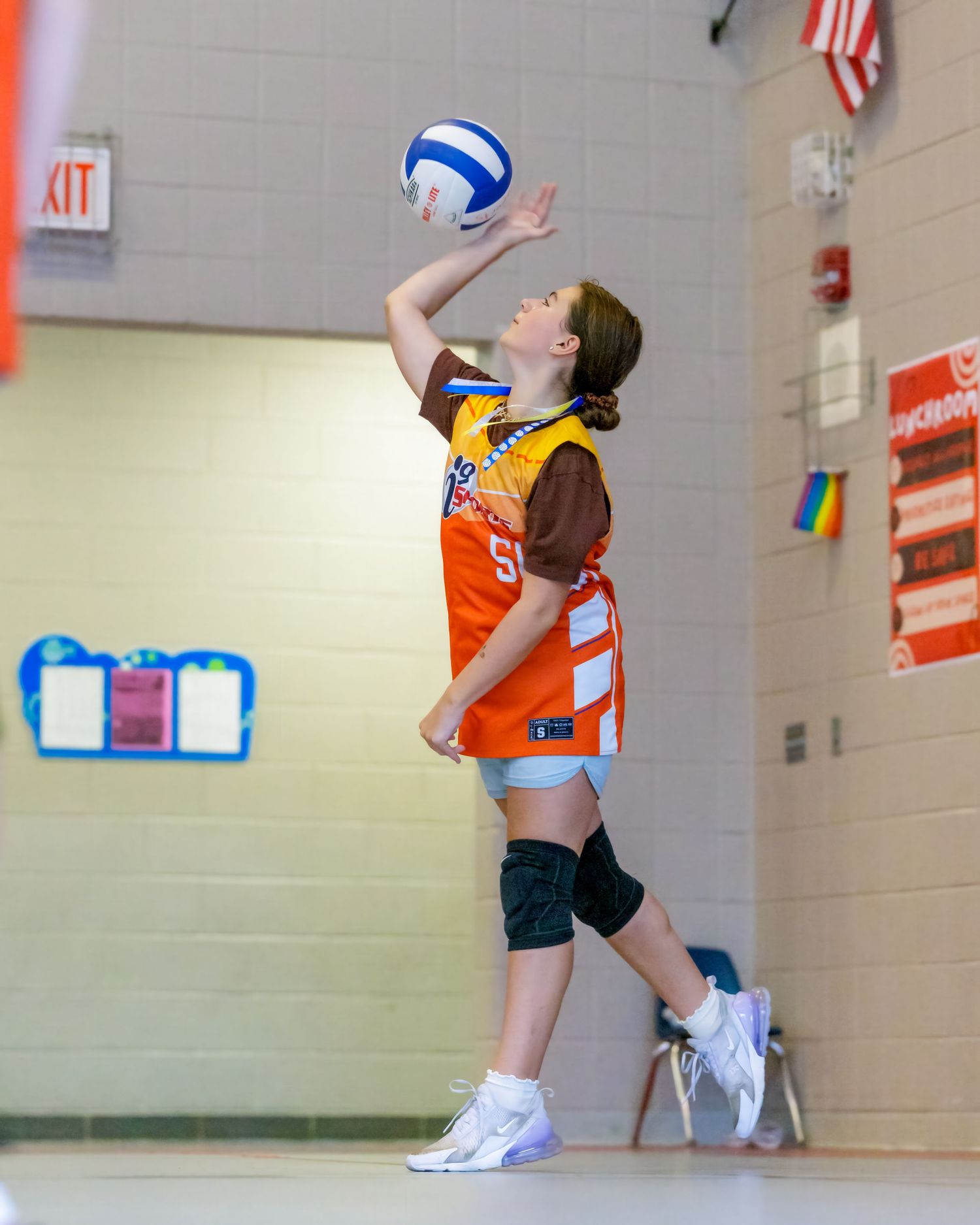 Volleyball player executes a powerful jump serve during an indoor match.