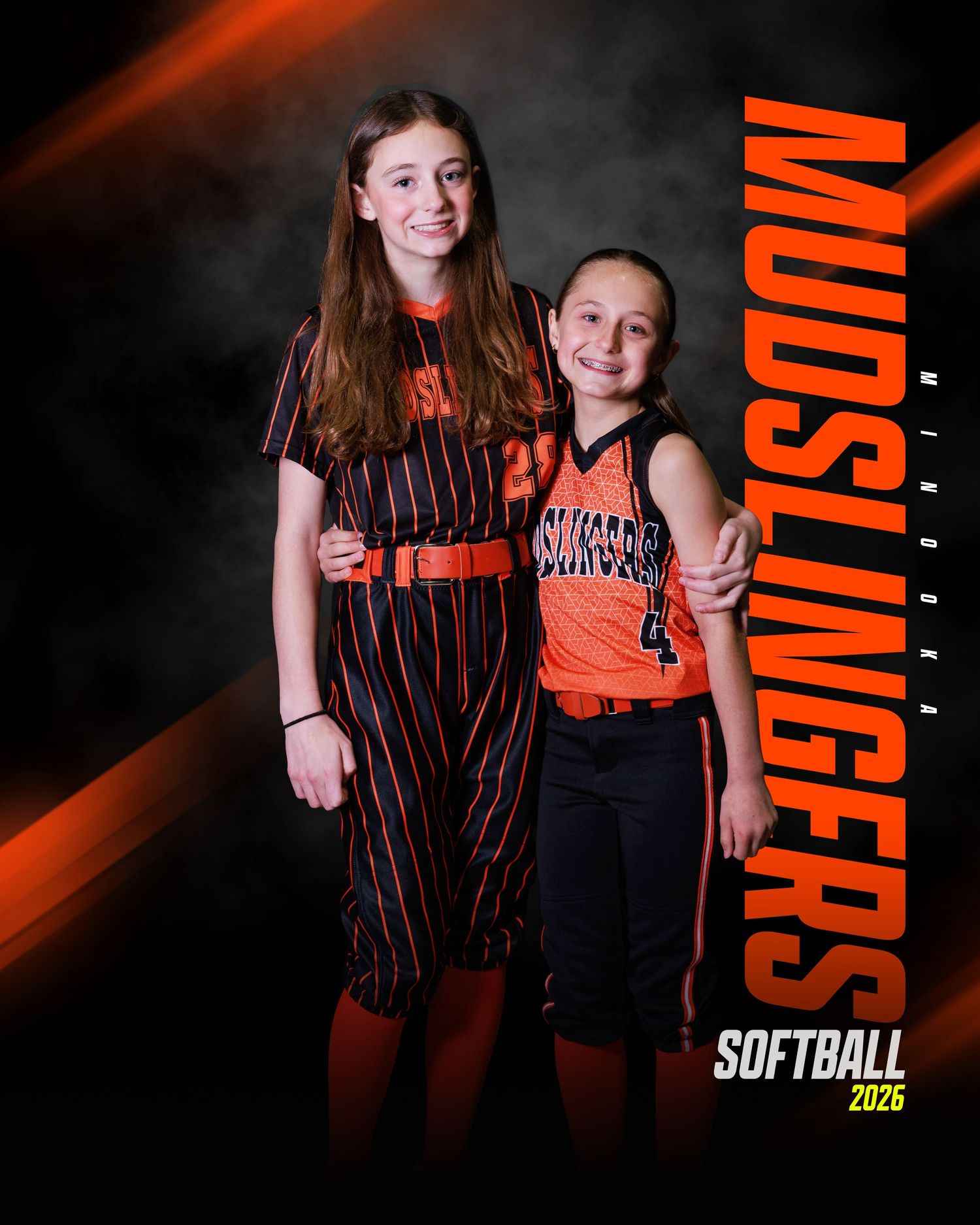 Two young girls in Mudslingers softball uniforms pose together for a 2026 team portrait photo.