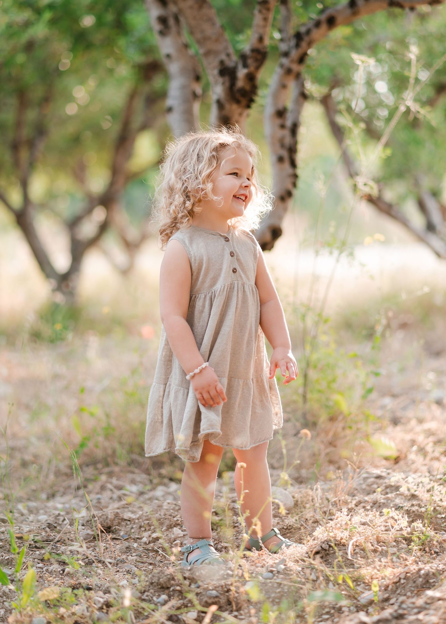 Sweet candid images of a young child exploring outdoors in a light colored dress. Fotograf Rhodos