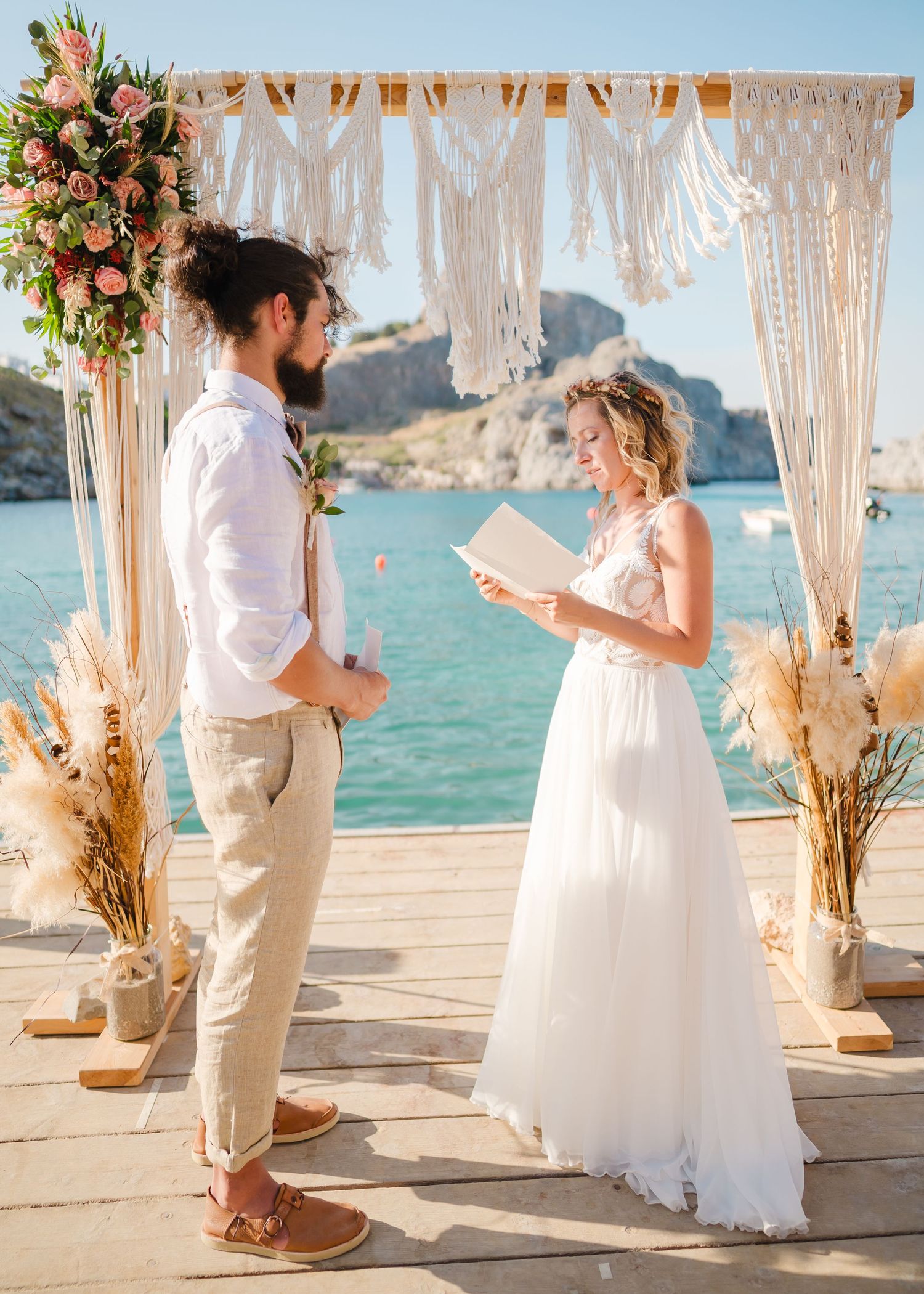 Seaside wedding ceremony with macrame arch and pampas grass decorations agaStrandhochzeit Rhodos - Hochzeitsfotograf inst mountain backdrop.