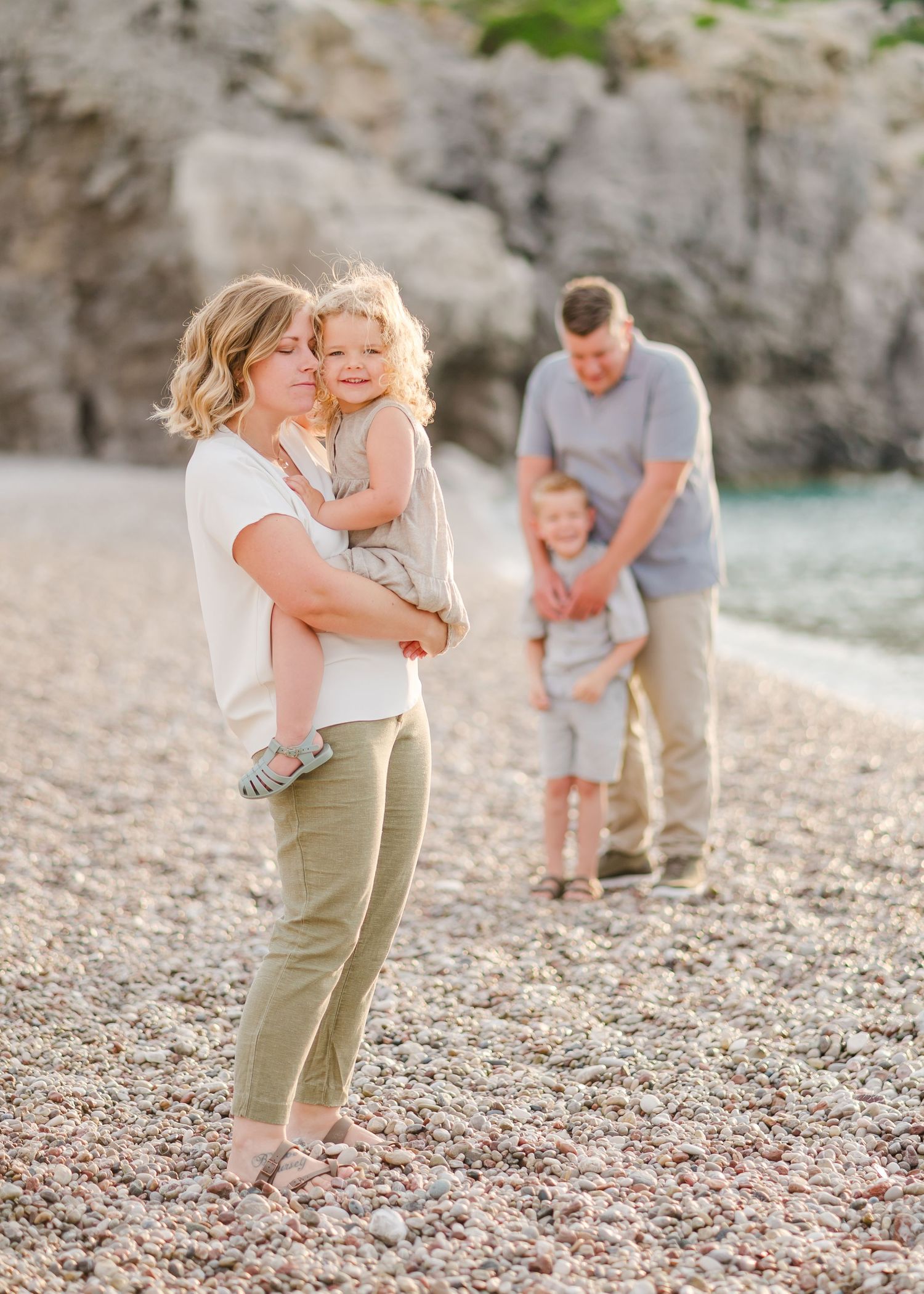 Beautiful family beach photography session with rocky cliffs and ocean backdrop. Fotograf Rhodos