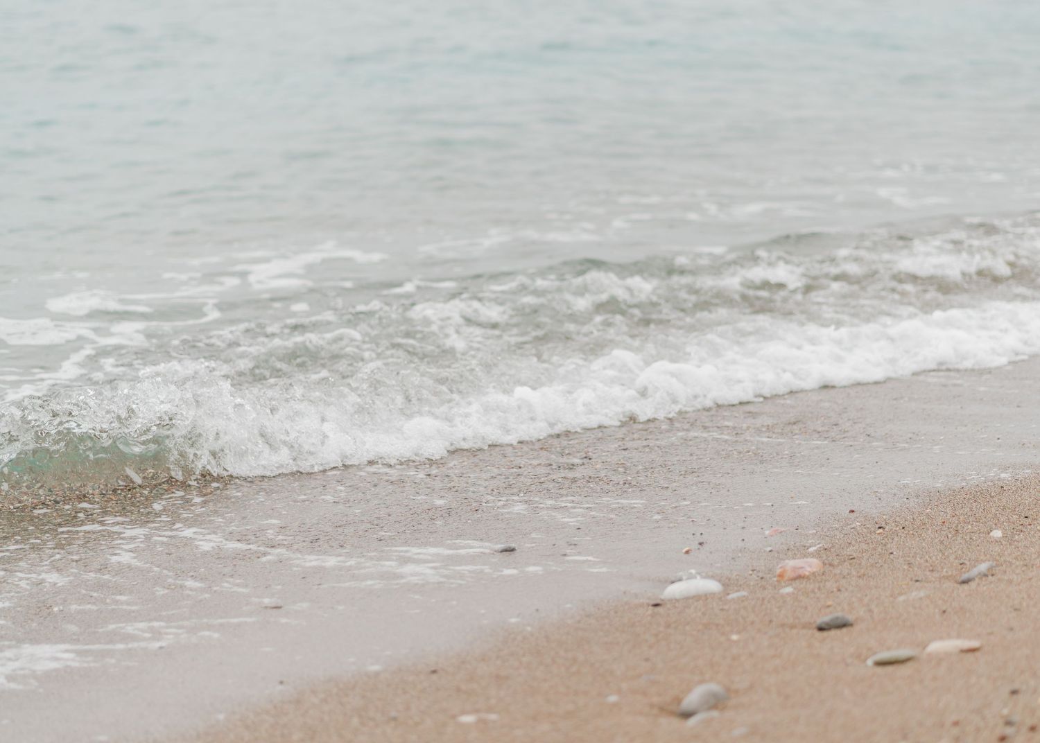 Gentle waves lapping at the shore of a serene beachfront wedding venue.