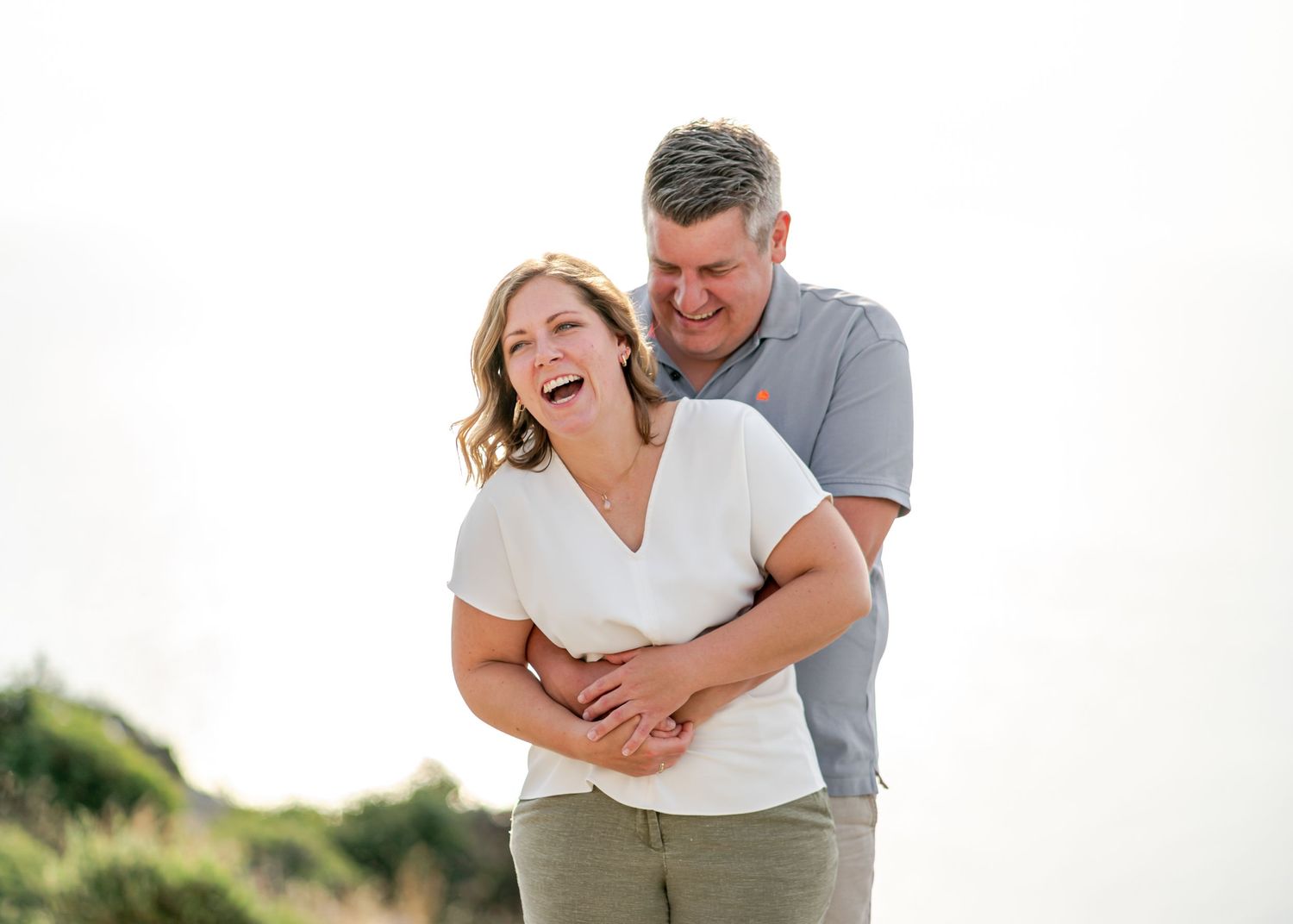 Couple shares intimate embrace during outdoor photo session against white background. Fotograf Rhodos